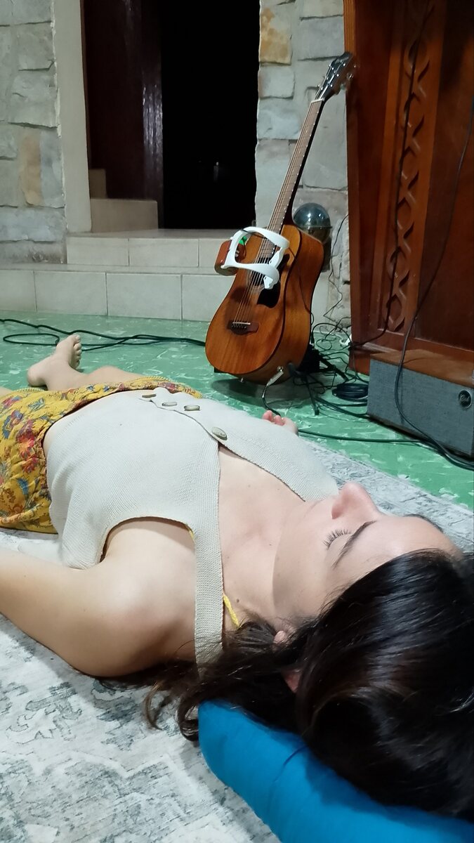 A person resting, the Beacon on a guitar behind